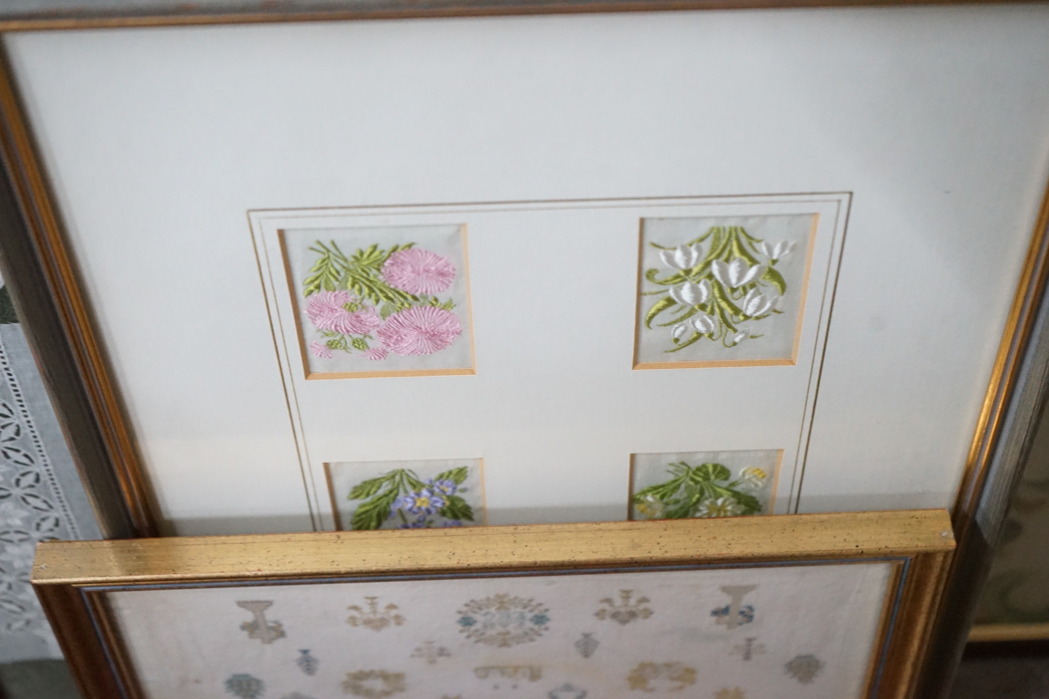 Eight framed embroideries / lace panels including a sampler